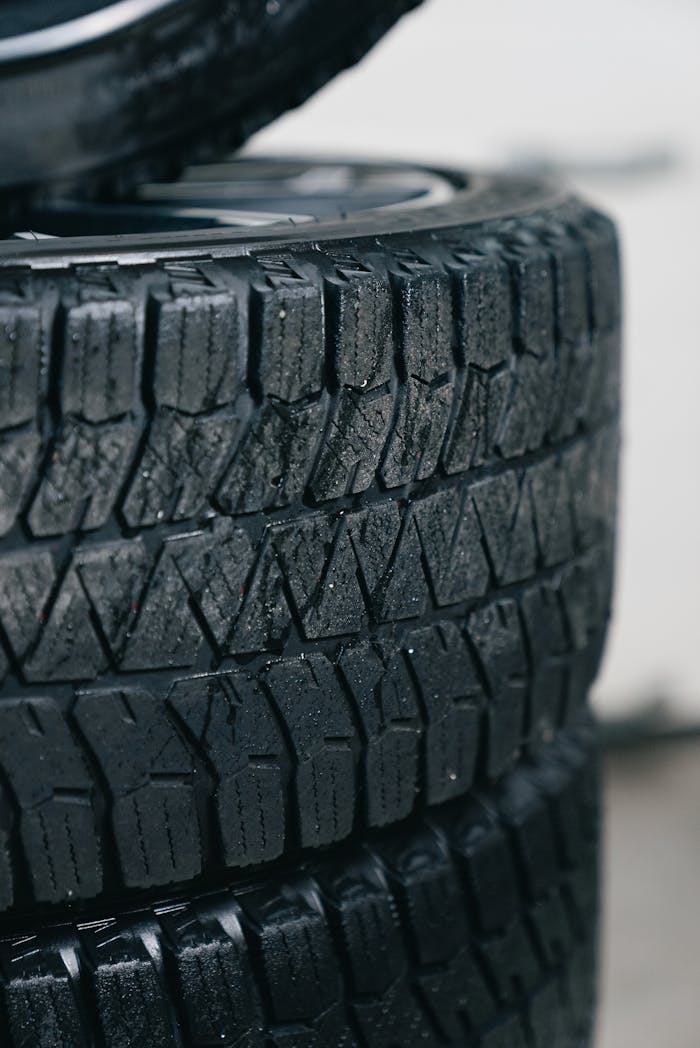 Detailed focus on stacked car tires showcasing intricate tread patterns for grip and traction.